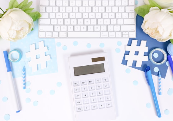 white and black calculator on white and blue textile