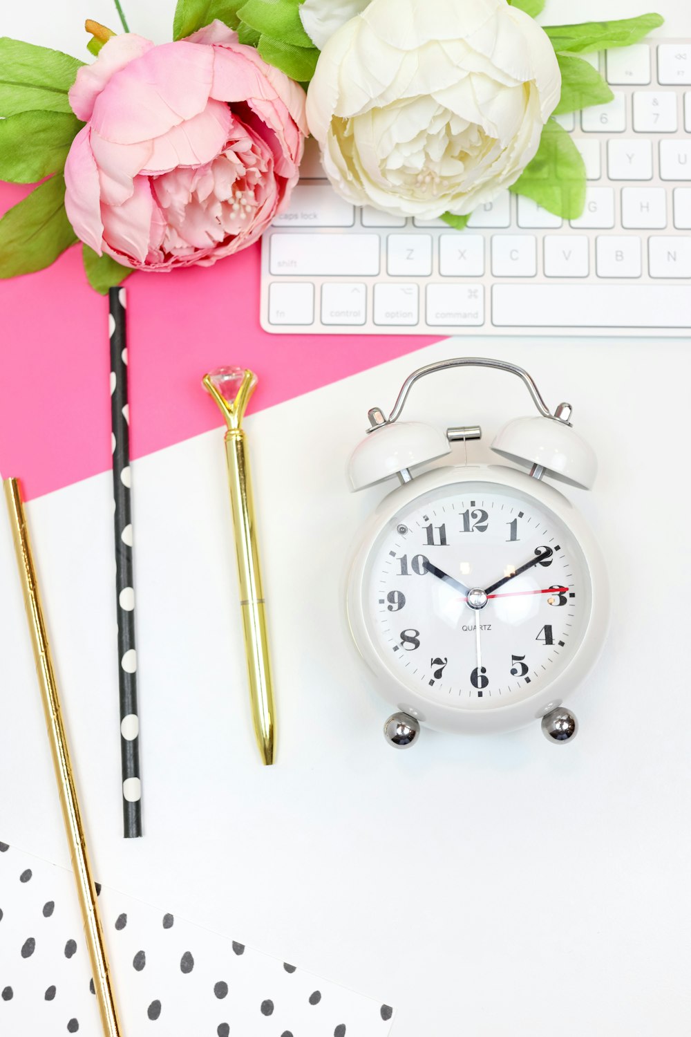 silver and white analog alarm clock