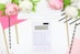 white calculator beside pink rose