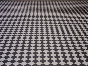 A floor with a repetitive black and white checkered pattern creating a strong optical illusion effect.