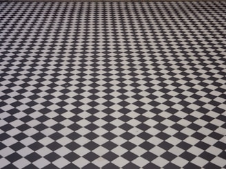 A floor with a repetitive black and white checkered pattern creating a strong optical illusion effect.
