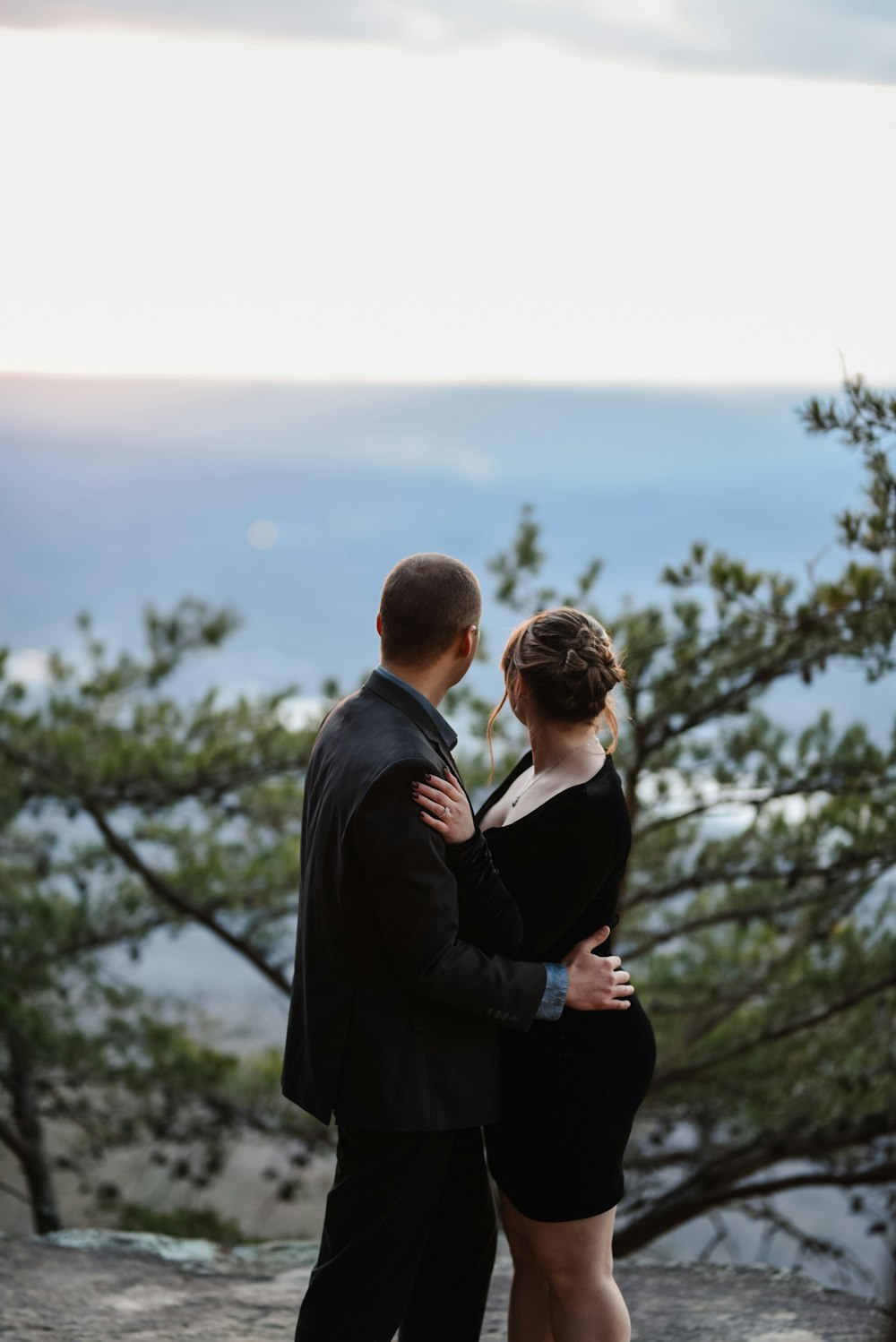 man in black suit standing in front of woman in black blazer