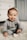baby in gray sweater lying on white textile