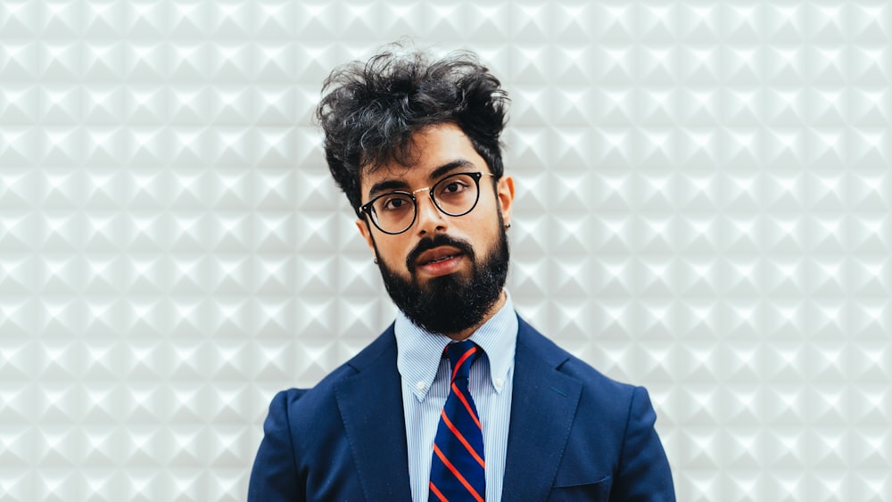 man in blue suit jacket wearing eyeglasses