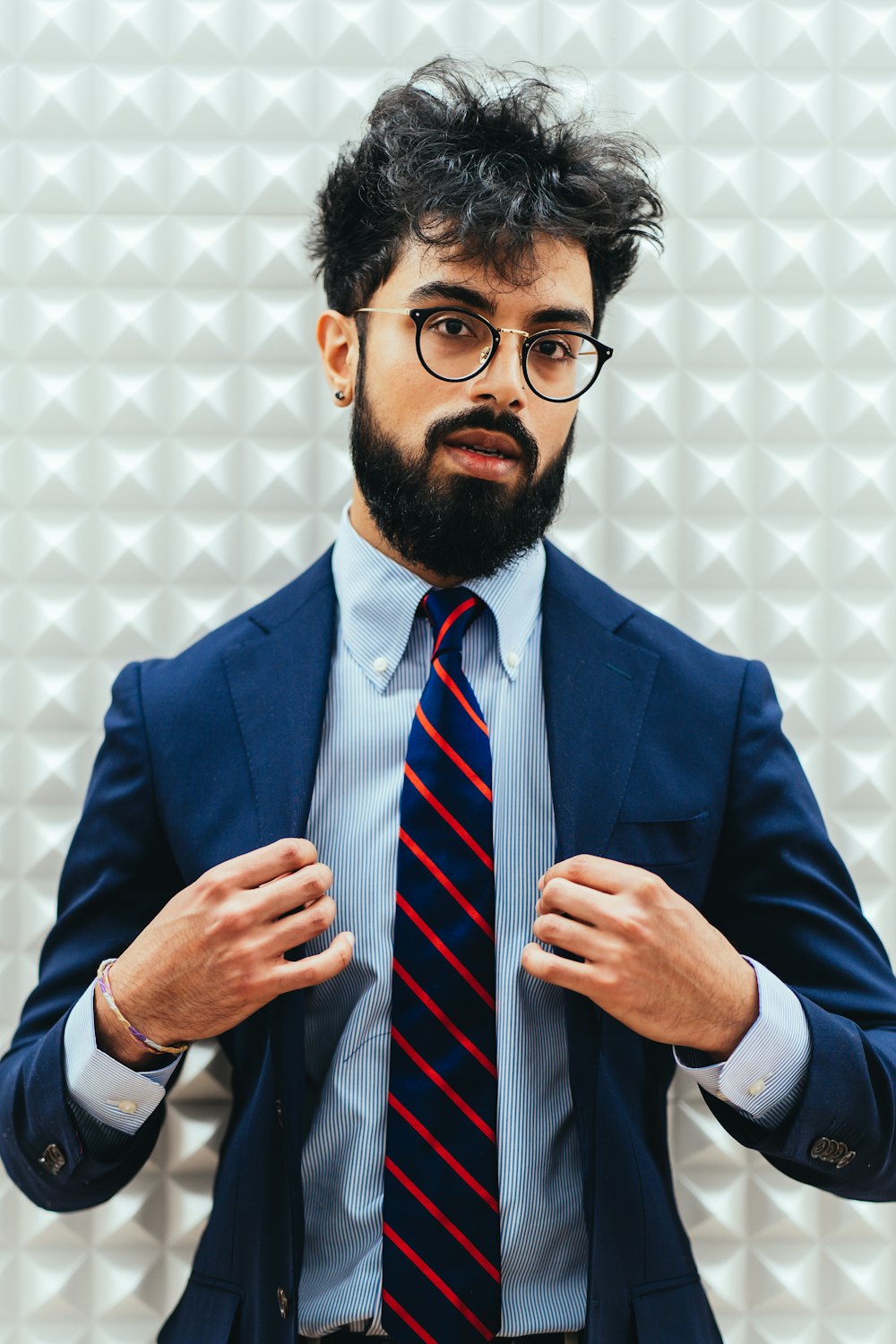 Hombre con traje azul con gafas de montura negra