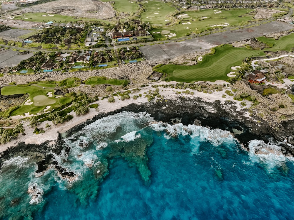 Veduta aerea del campo di erba verde vicino allo specchio d'acqua durante il giorno