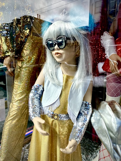 A mannequin dressed in a glamorous outfit, accessorized with elegant jewelry.