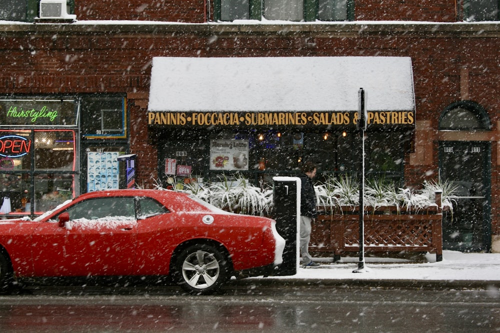 red sedan parked beside store during daytime