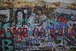 a wall covered in lots of graffiti and writing
