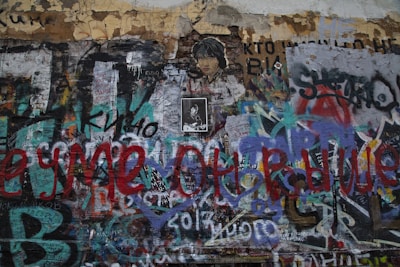 a wall covered in lots of graffiti and writing