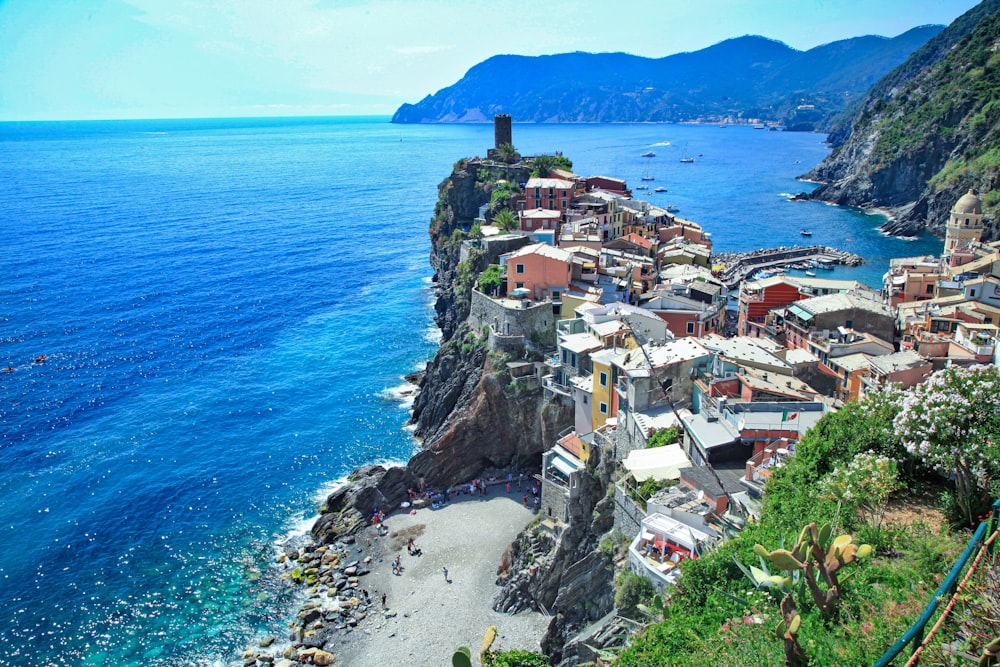 houses on cliff by the sea during daytime