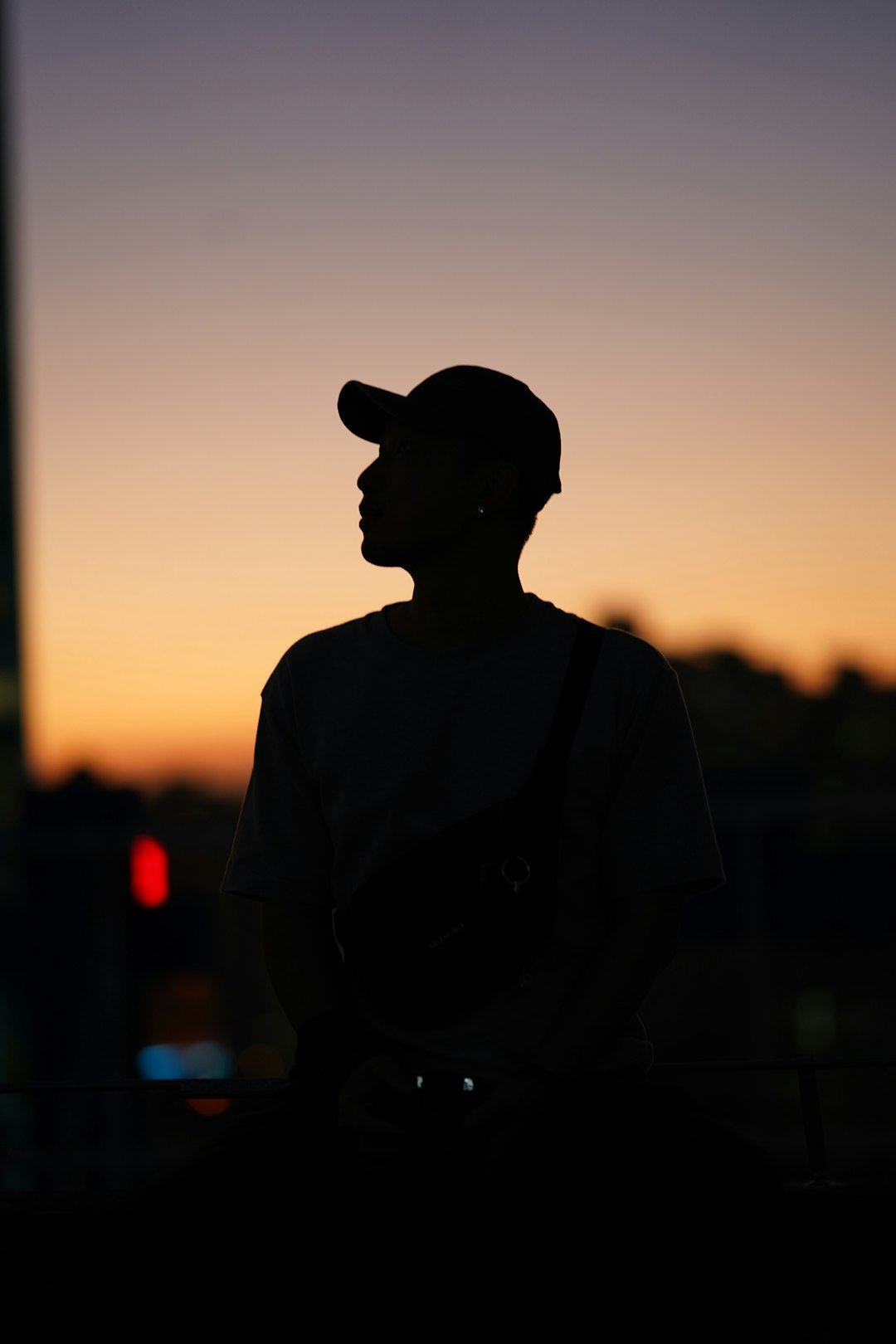 man in black hat and brown shirt standing on road during sunset