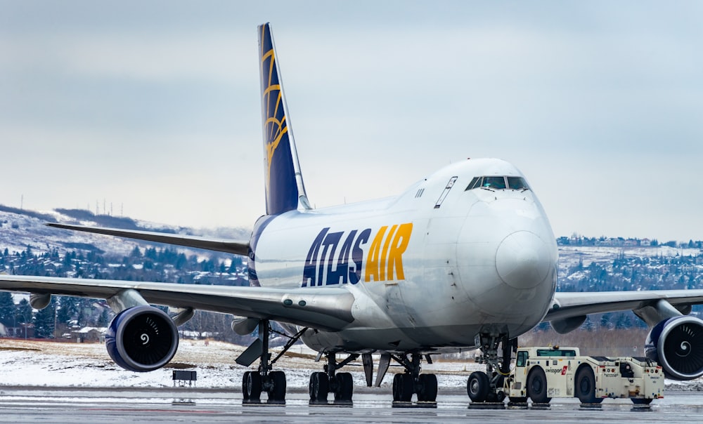 weißes und blaues Flugzeug tagsüber am Flughafen