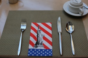 silver fork and bread knife on white ceramic plate