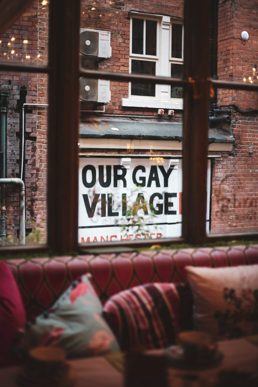 Our Gay Village Sign seen through window