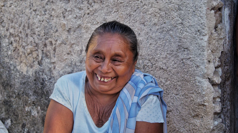 Sugar Mommy sonriente con camisa a rayas blancas y azules.