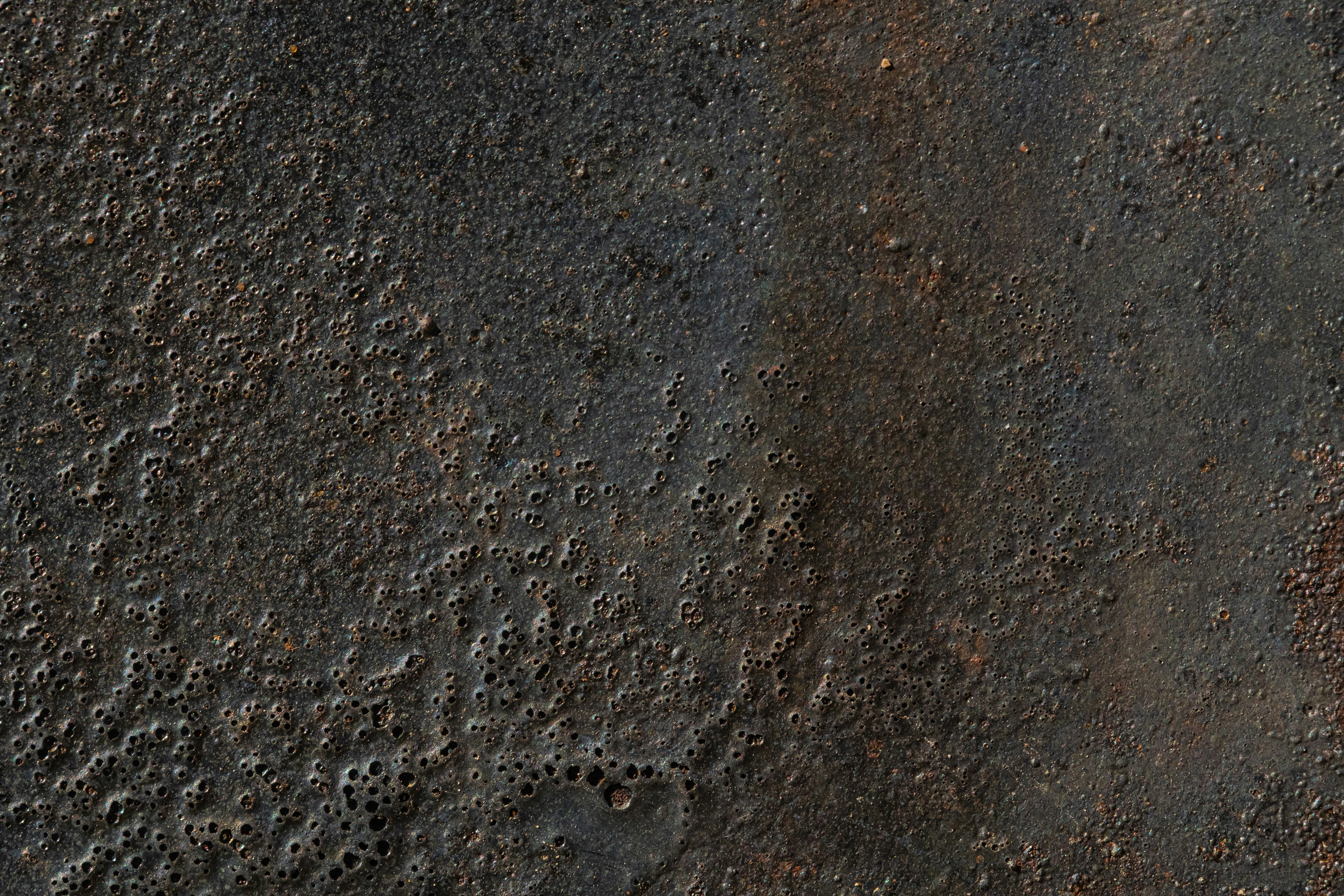 person wearing black leather shoes standing on gray concrete floor
