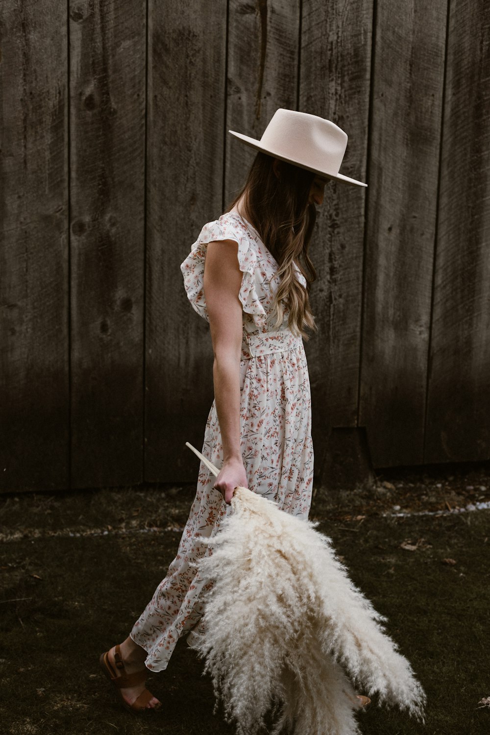 Mujer con vestido floral blanco con sombrero marrón