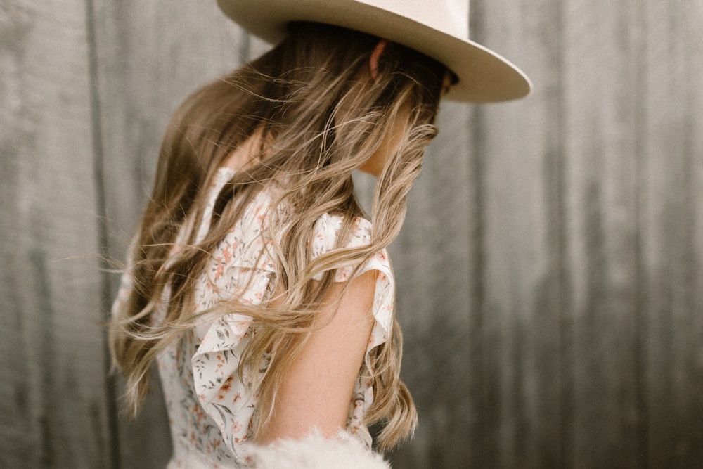 Mujer con vestido floral blanco con sombrero marrón