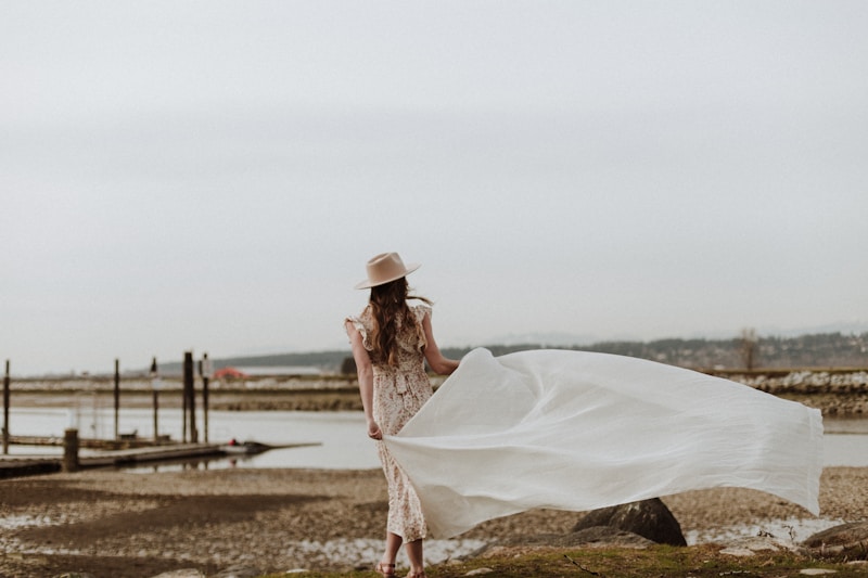 Fashionable woman in white dress on rock