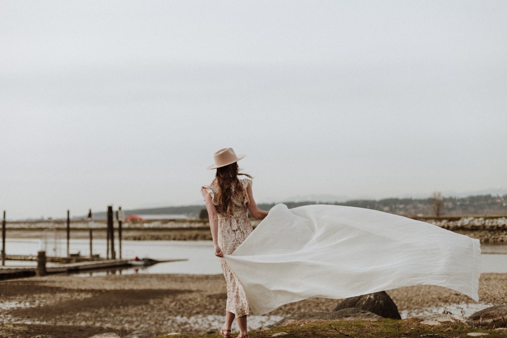 woman in white dress sitting on brown rock during daytime