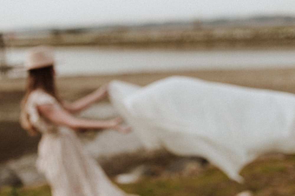 woman in white dress sitting on green grass field during daytime