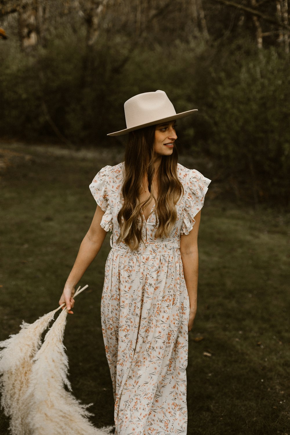 Mujer con vestido floral blanco y rojo con sombrero blanco para el sol