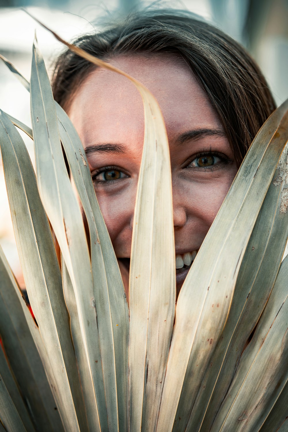 woman covering her face with white leaves