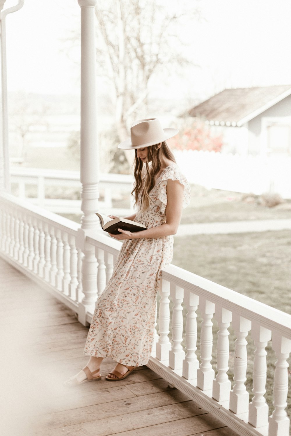 woman in white floral dress standing on wooden bridge