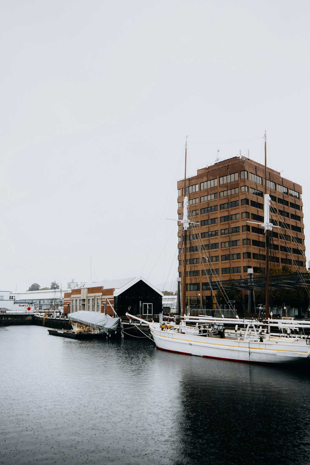 white and brown boat on water near city buildings during daytime