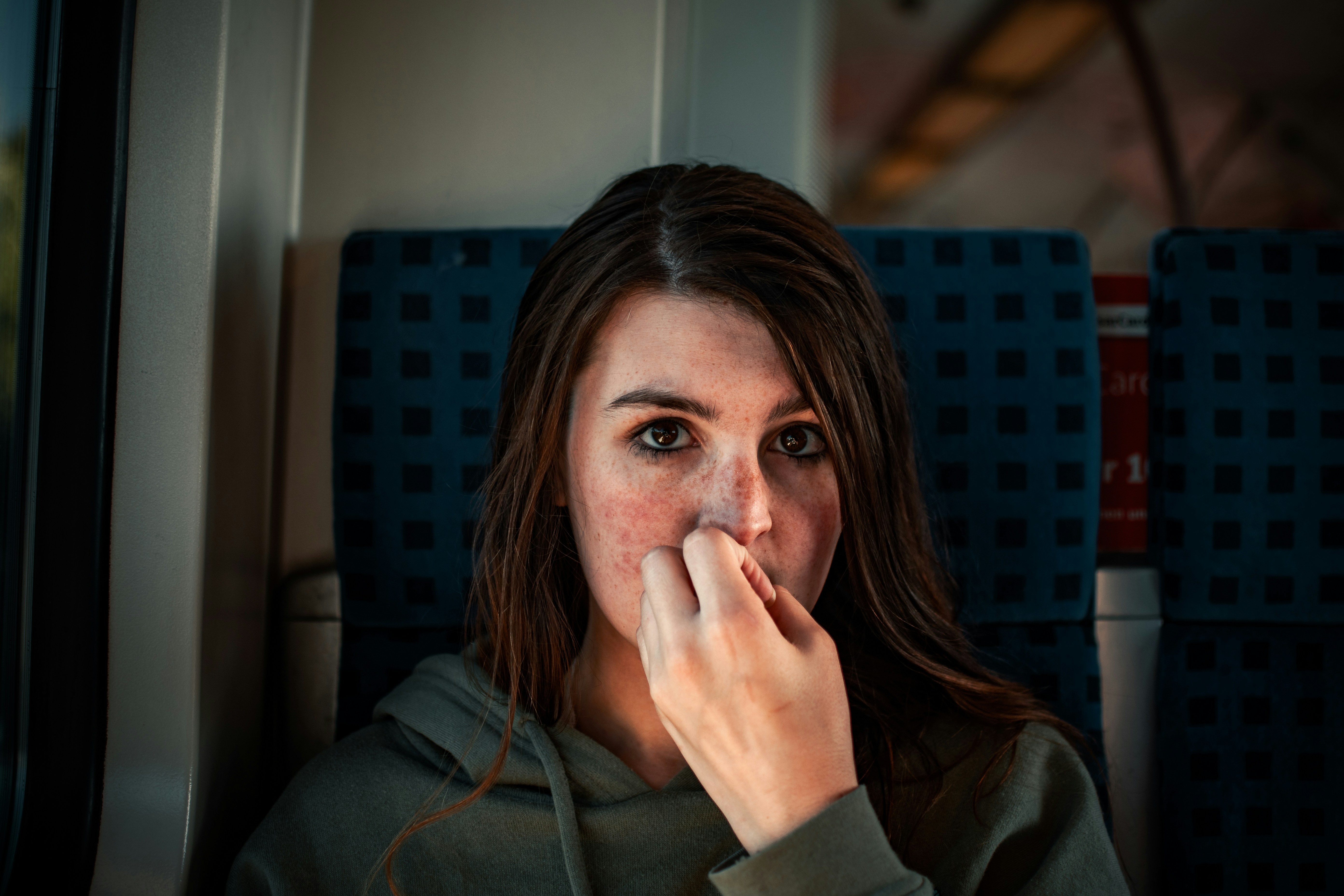woman in gray jacket sitting on purple chair, 