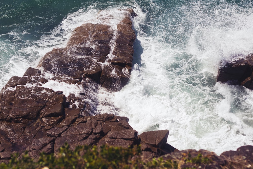 brown rock formation beside body of water during daytime