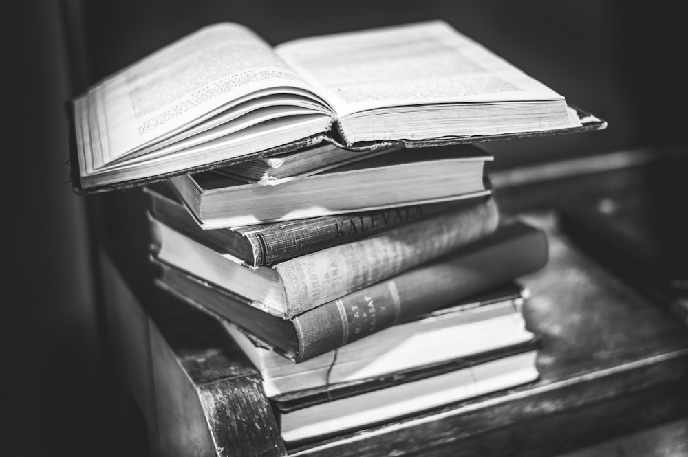 grayscale photo of books on table