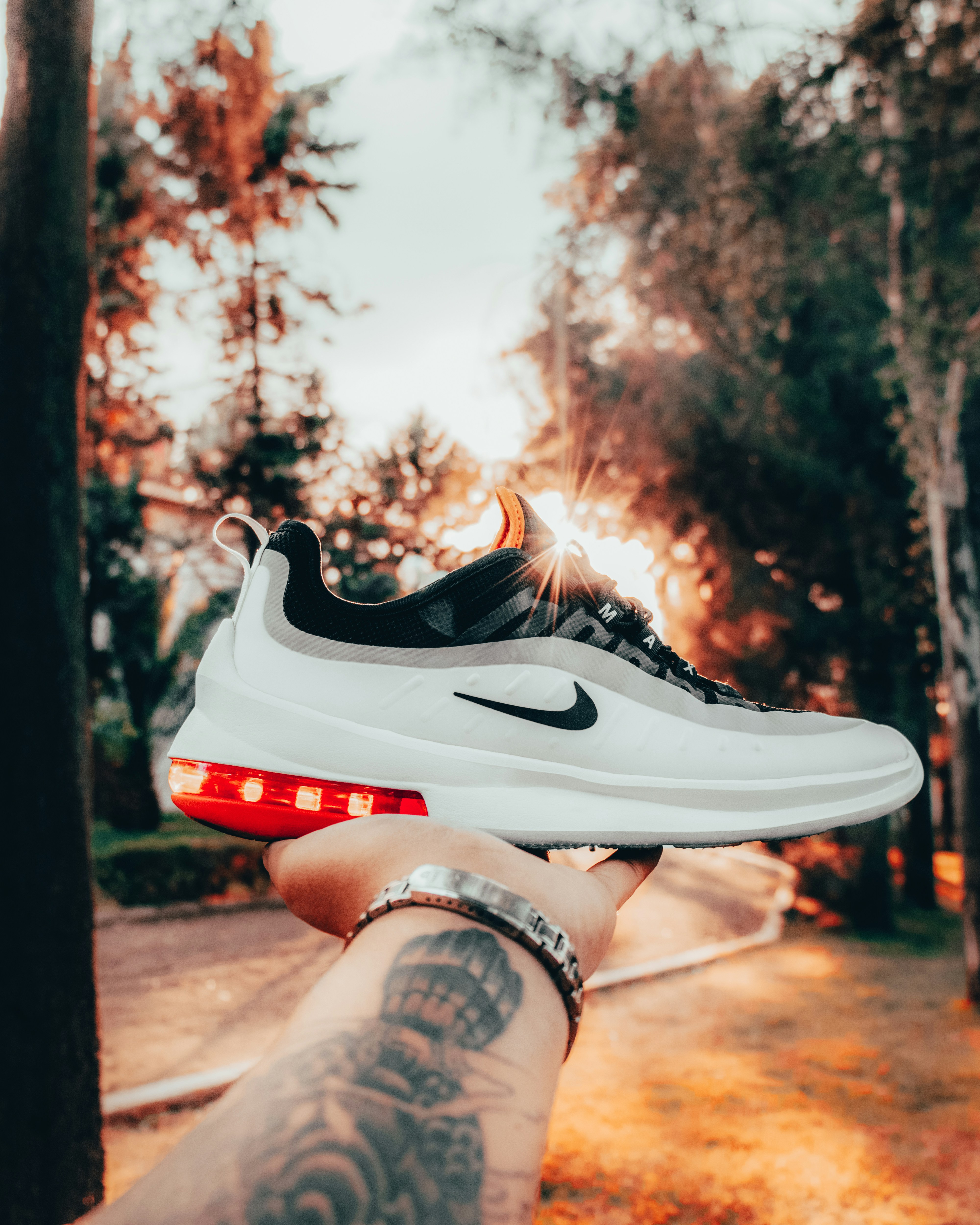 person holding white and red nike air max