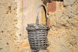 Traditional woven basket displayed outdoors against an ancient stone wall