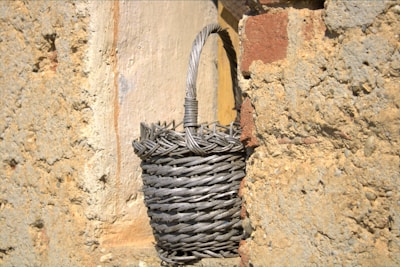 Traditional woven basket displayed outdoors against an ancient stone wall