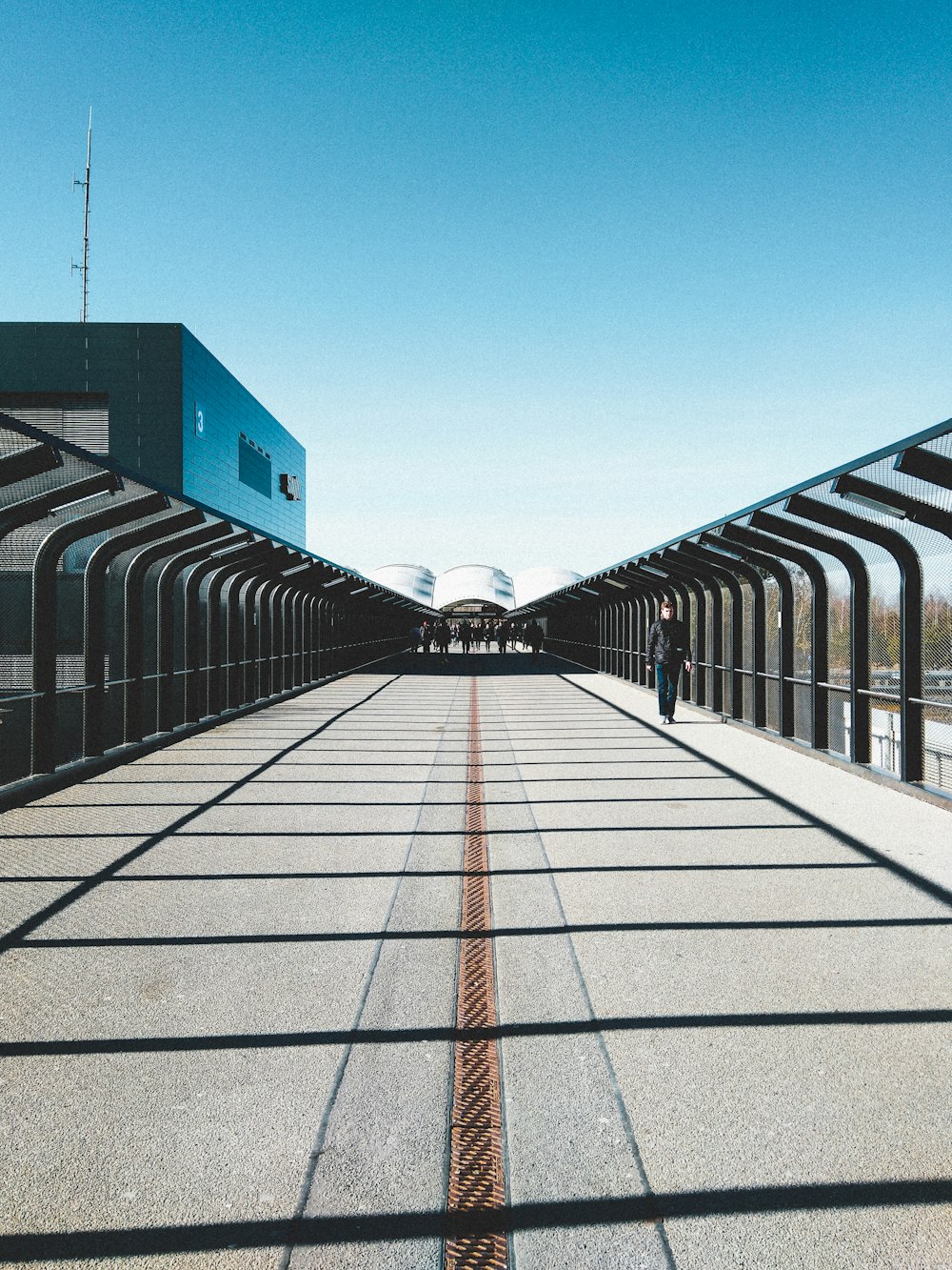 gray concrete pathway between blue and red building during daytime