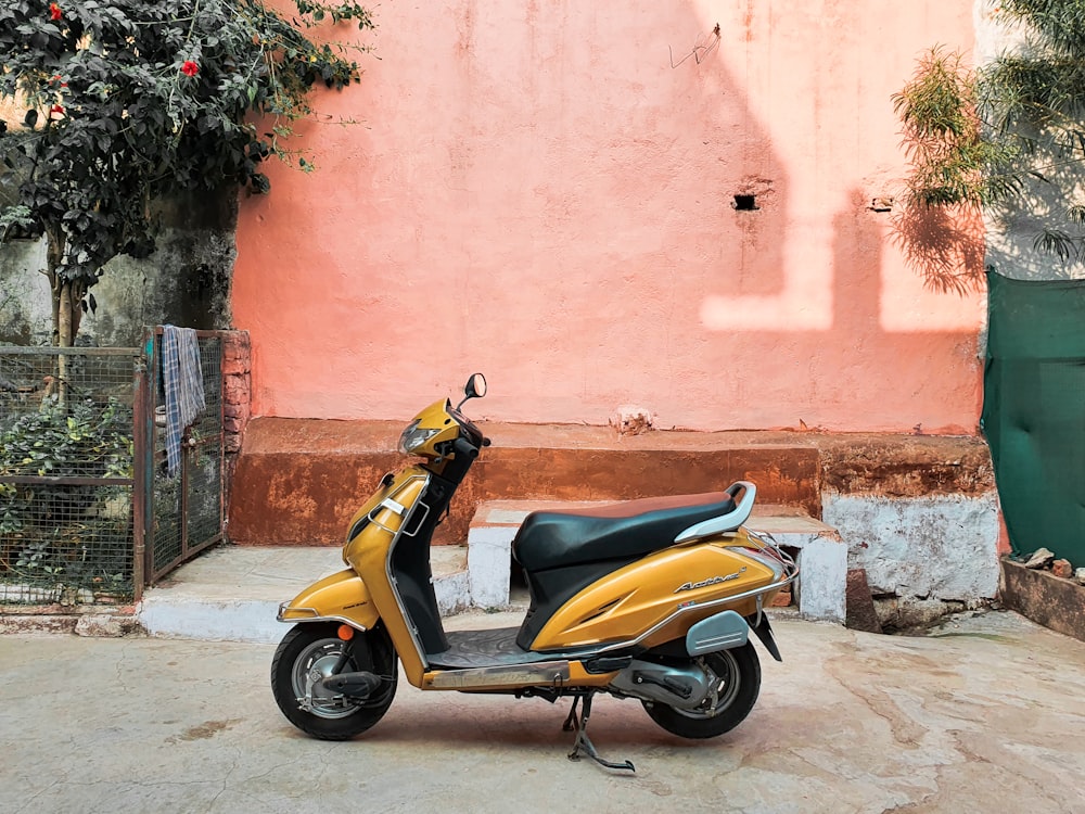 yellow and black motor scooter parked beside pink concrete wall during  daytime photo – Free Cool photo Image on Unsplash