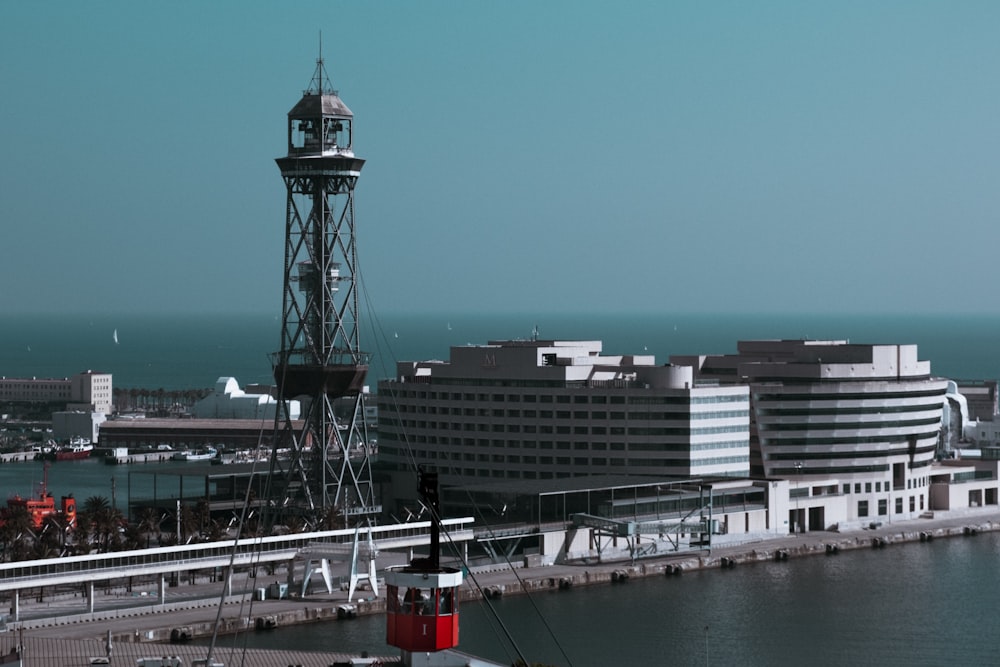 Tour blanche et rouge près d’un plan d’eau pendant la journée