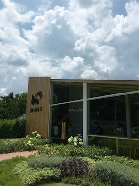 A sleek, modern garden cube office surrounded by lush greenery on a sunny day.