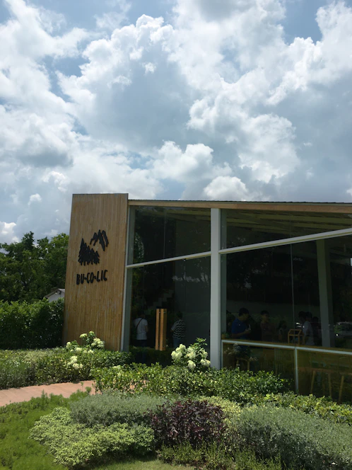 A modern luxury prefabricated bungalow surrounded by lush greenery under a clear blue sky.