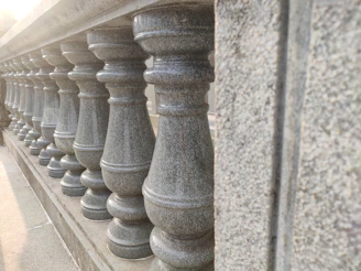 A series of stone pier caps arranged neatly, highlighting different shapes and finishes in natural light.