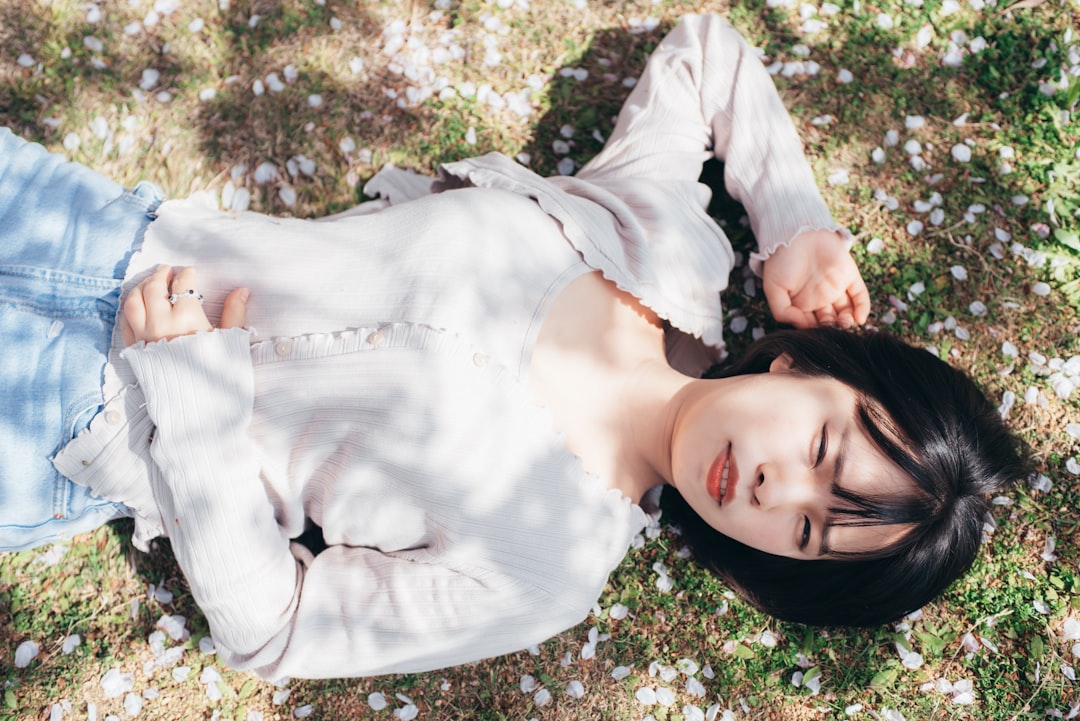 woman in white long sleeve shirt standing on green grass field