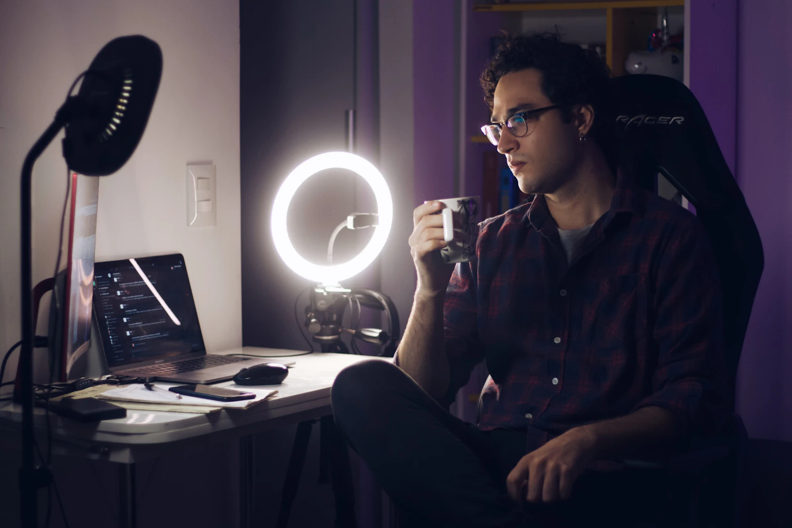 A person at a desk lit by a ring light