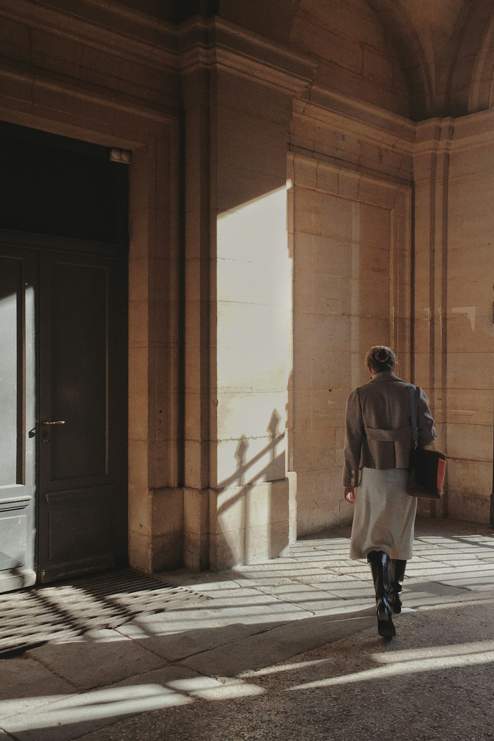 hombre con chaqueta gris caminando por el pasillo