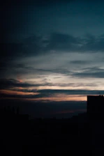 A moody cinematic shot of the Karachi skyline at dusk, with warm golden light casting long shadows.