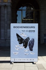 a poster on a sidewalk in front of a building