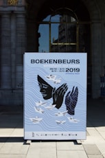 a poster on a sidewalk in front of a building