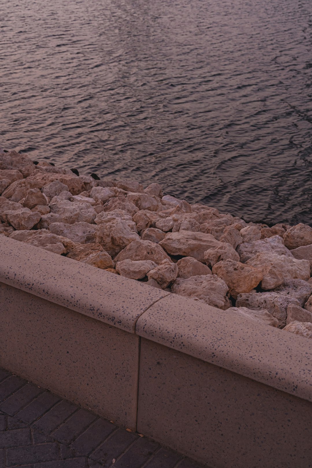 brown concrete wall near body of water during daytime