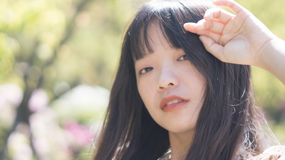 woman in black shirt holding her hair